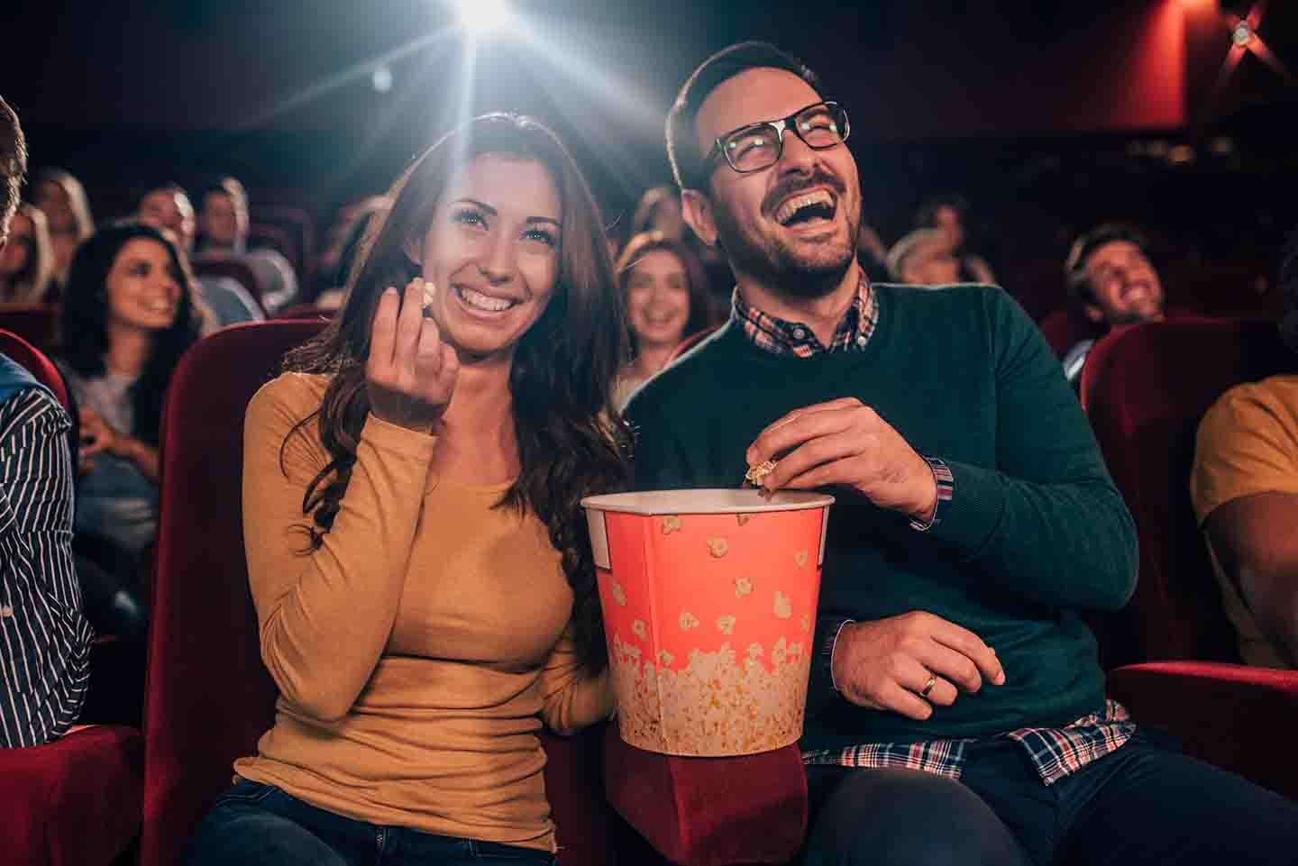 A couple enjoying a movie together at the theatre