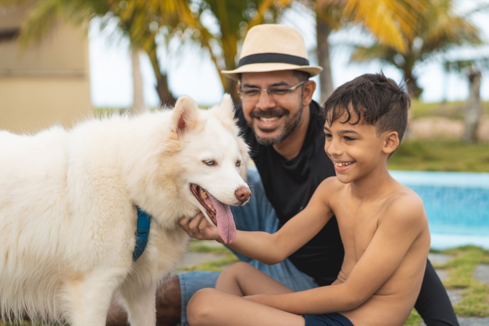Father and son petting their dog on vacation