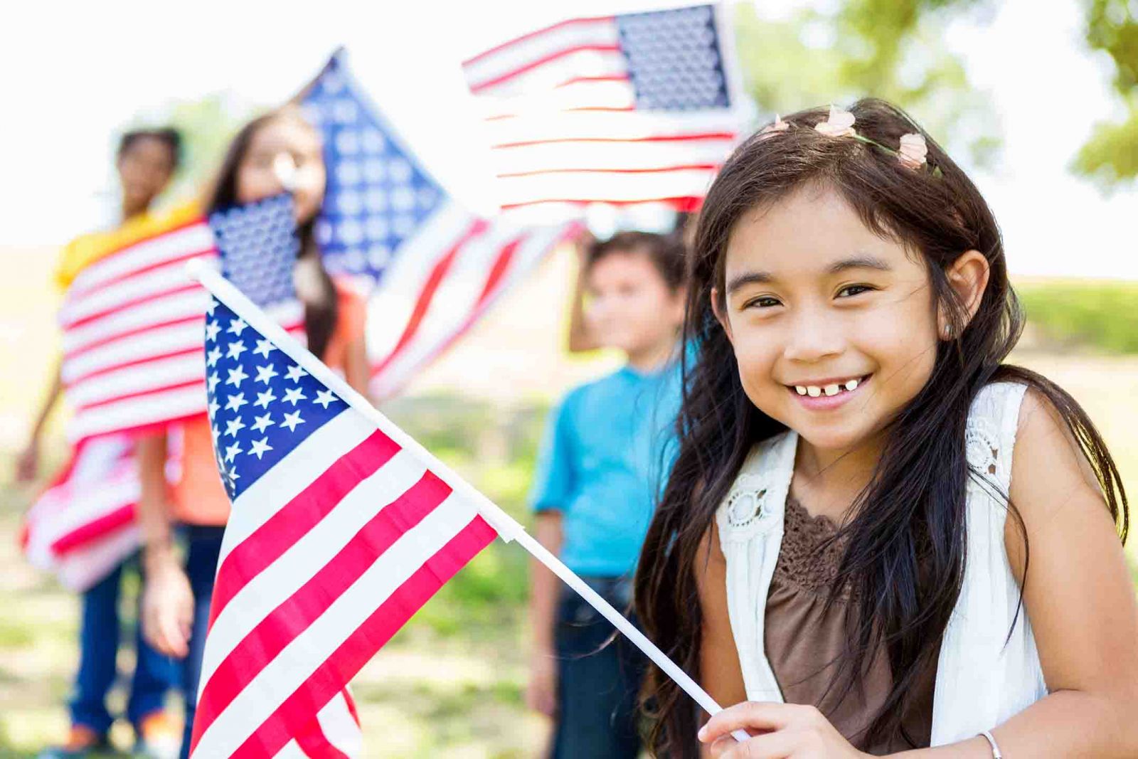 Little girl and her friends playing with American flags