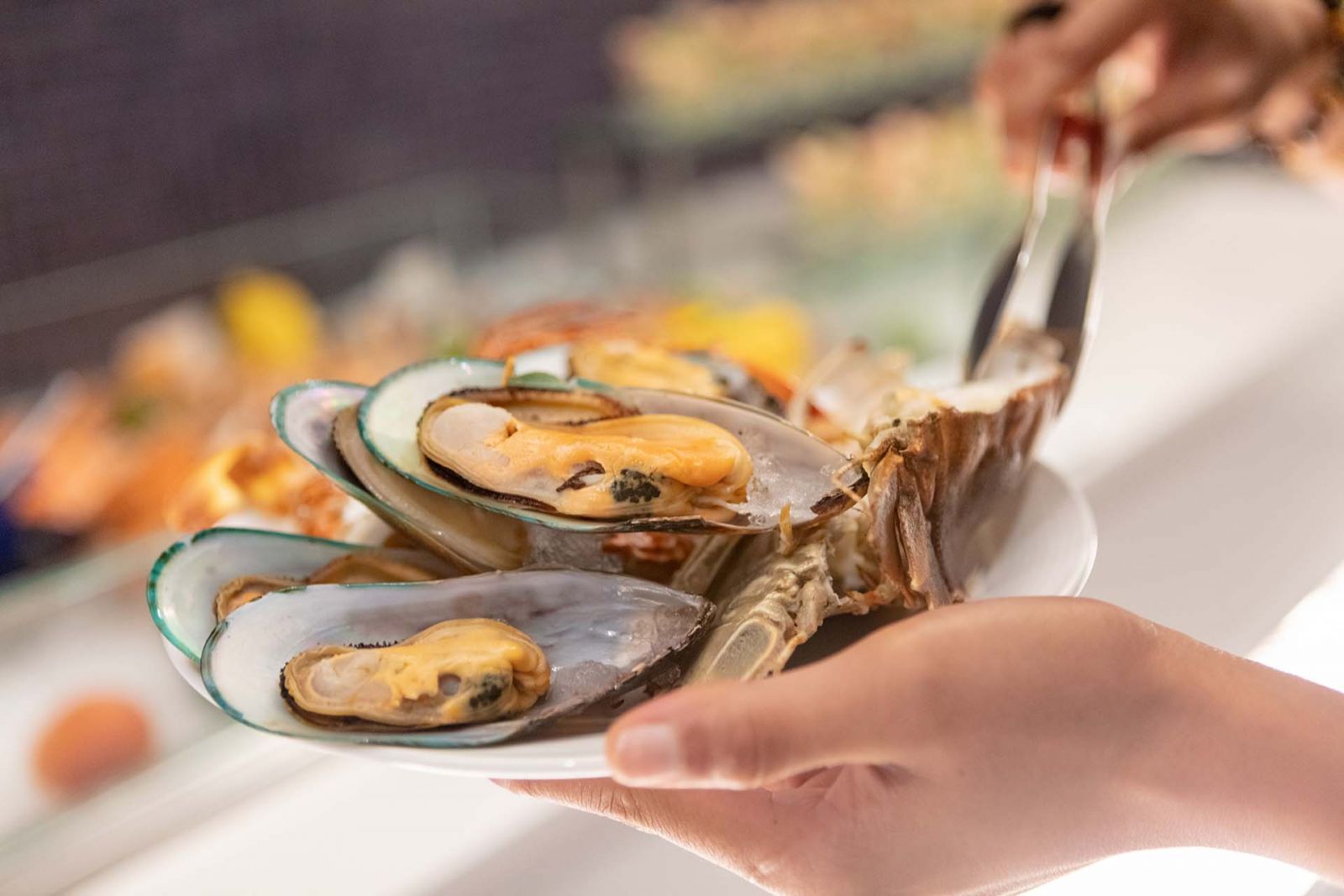 Woman grabbing oysters from the buffet