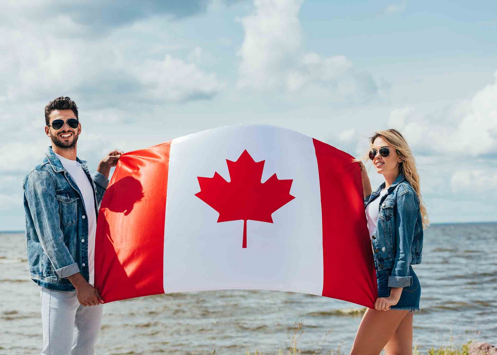 Couple holding a Canadian flag on the beach