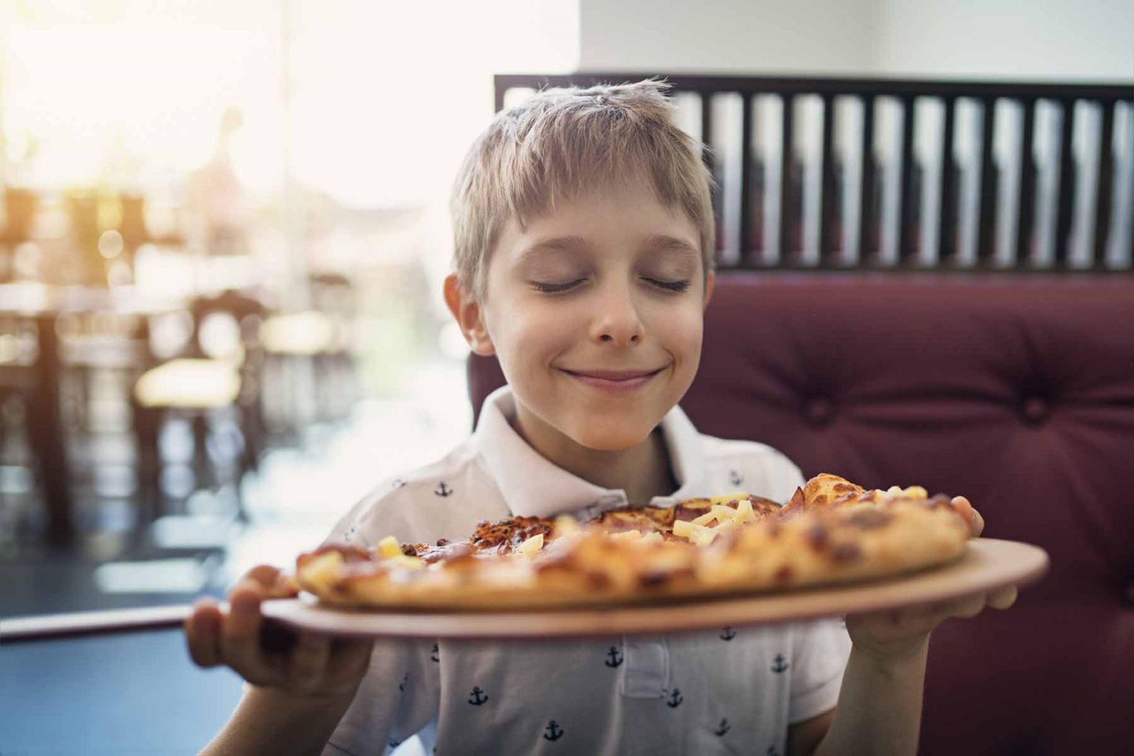 Young boy enjoying a freshly baked pizza at Surfside Pizza