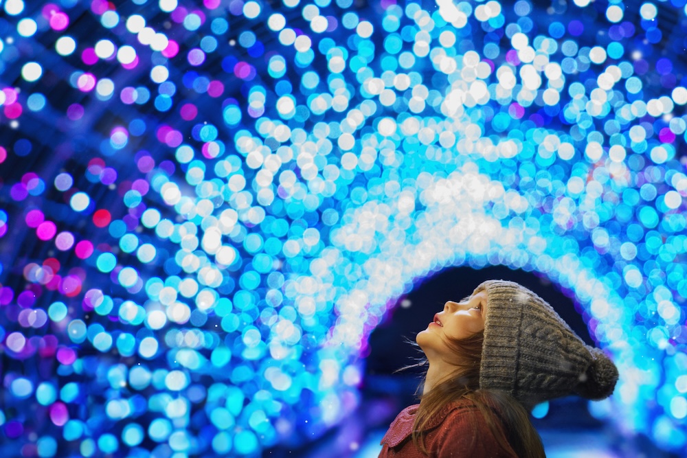 A child looking at holiday lights.