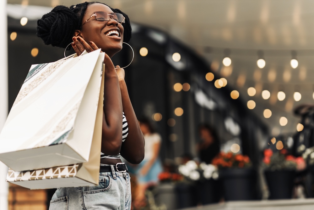 Woman, in the mall with shopping bag.